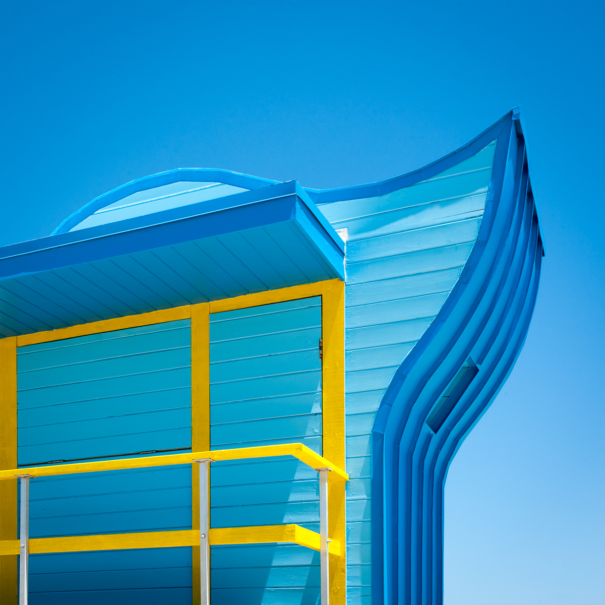 Blue and yellow South Beach lifeguard stand against a blue sky